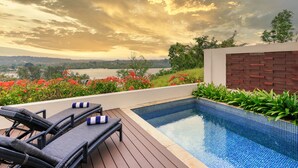 A poolside area with lounge chairs and a view of a lake at sunset. - Mangoes Resort (Port Vila)