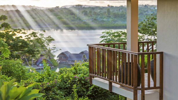 A balcony with a view of a lake and distant buildings. - Mangoes Resort (Port Vila)