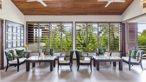 A spacious indoor area with wooden ceiling and large windows, offering views of lush greenery outside. - Mangoes Resort (Port Vila)