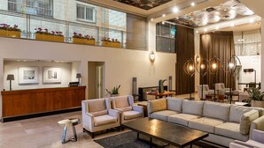 A spacious lobby with a reception desk, seating area, and large windows.