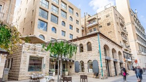 A Harmony Hotel with a stone facade, outdoor seating, and a visible storefront.