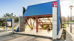 Una estación de metro con techo azul y un letrero rojo que dice 'metro'.
