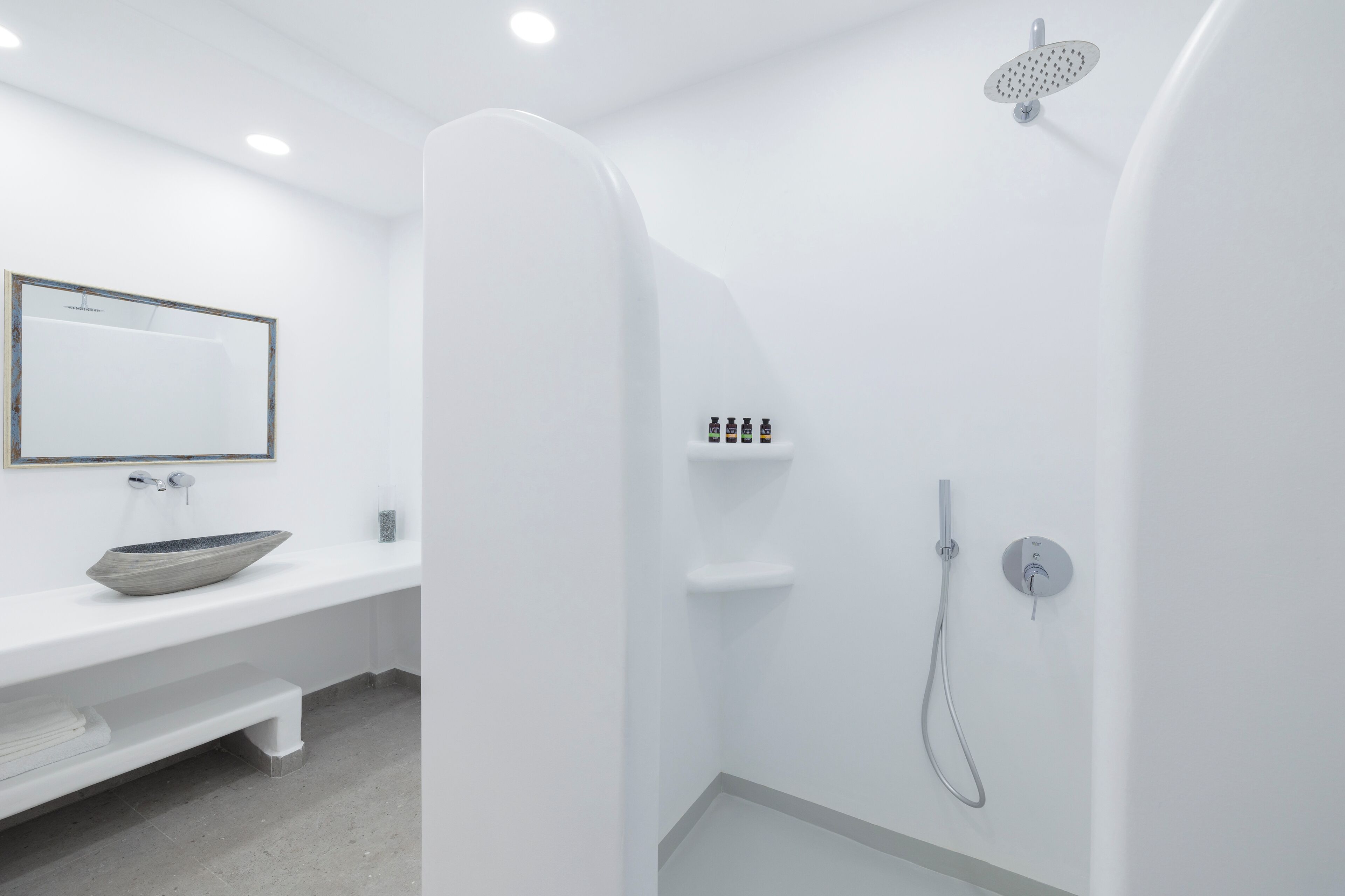 A modern bathroom with a large bathtub, a shower, and a vanity with a bowl sink.