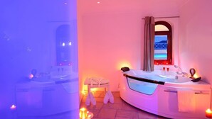 A modern bathroom with a freestanding bathtub, a vanity, and a mirror. - Absolute Bliss (Santorini)