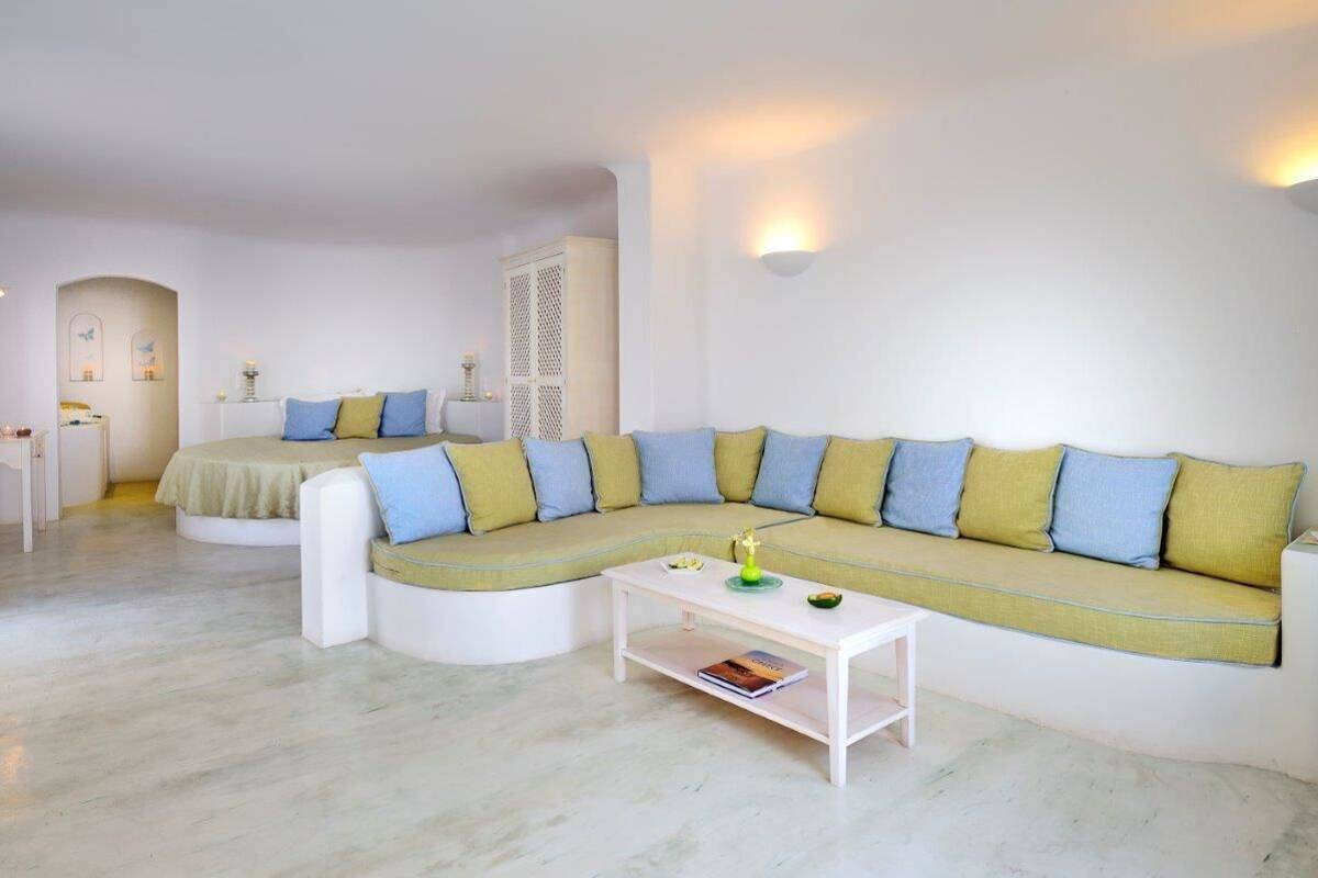 A modern living room with a curved sofa, a white coffee table, and a small side table.