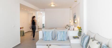 A modern living room with a grey sofa, white coffee table, and decorative pillows.