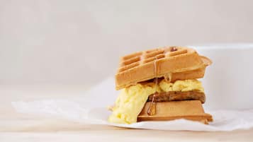 Sándwich de gofres con almíbar y una porción de helado.