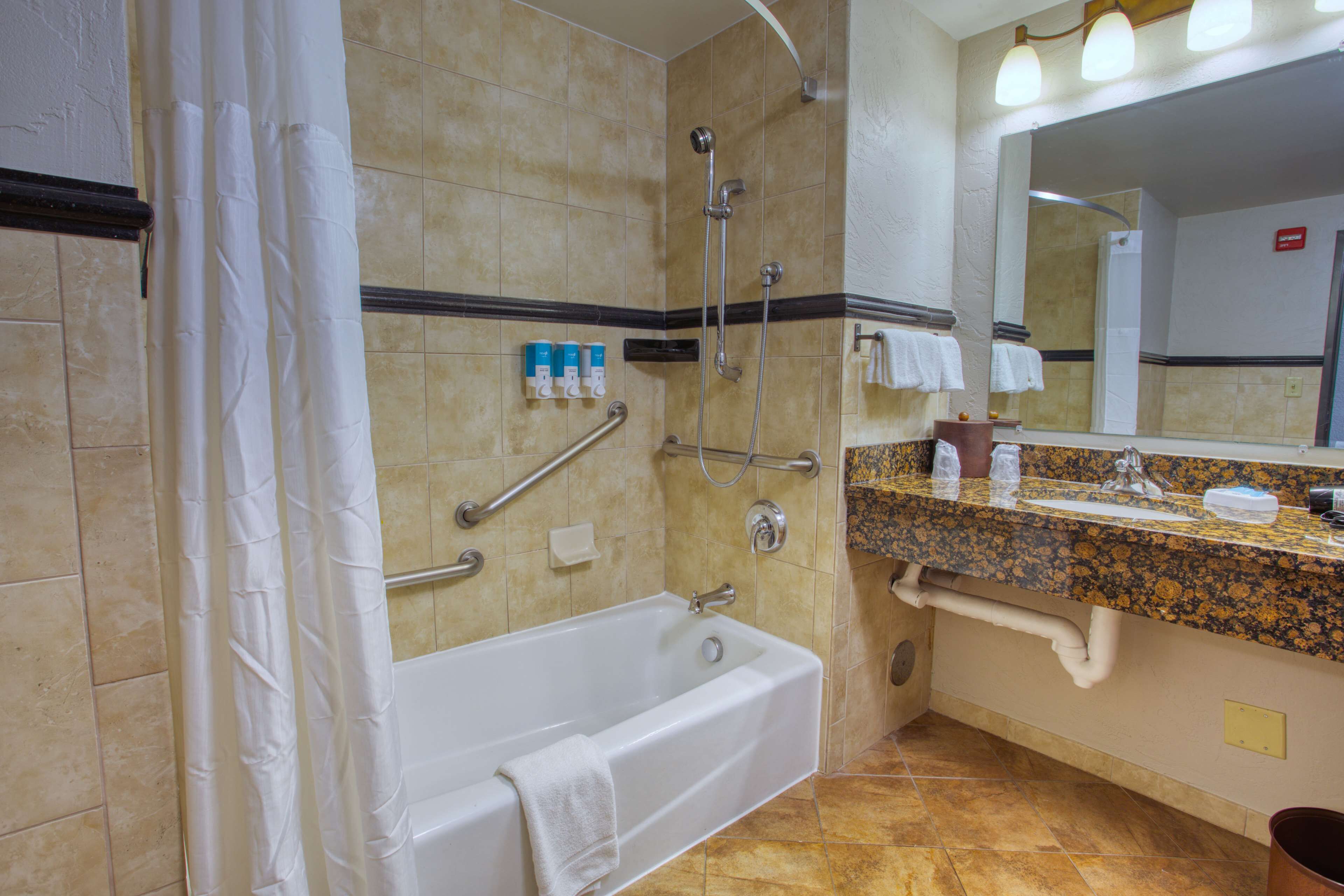 A bathroom with a bathtub, shower, and sink.