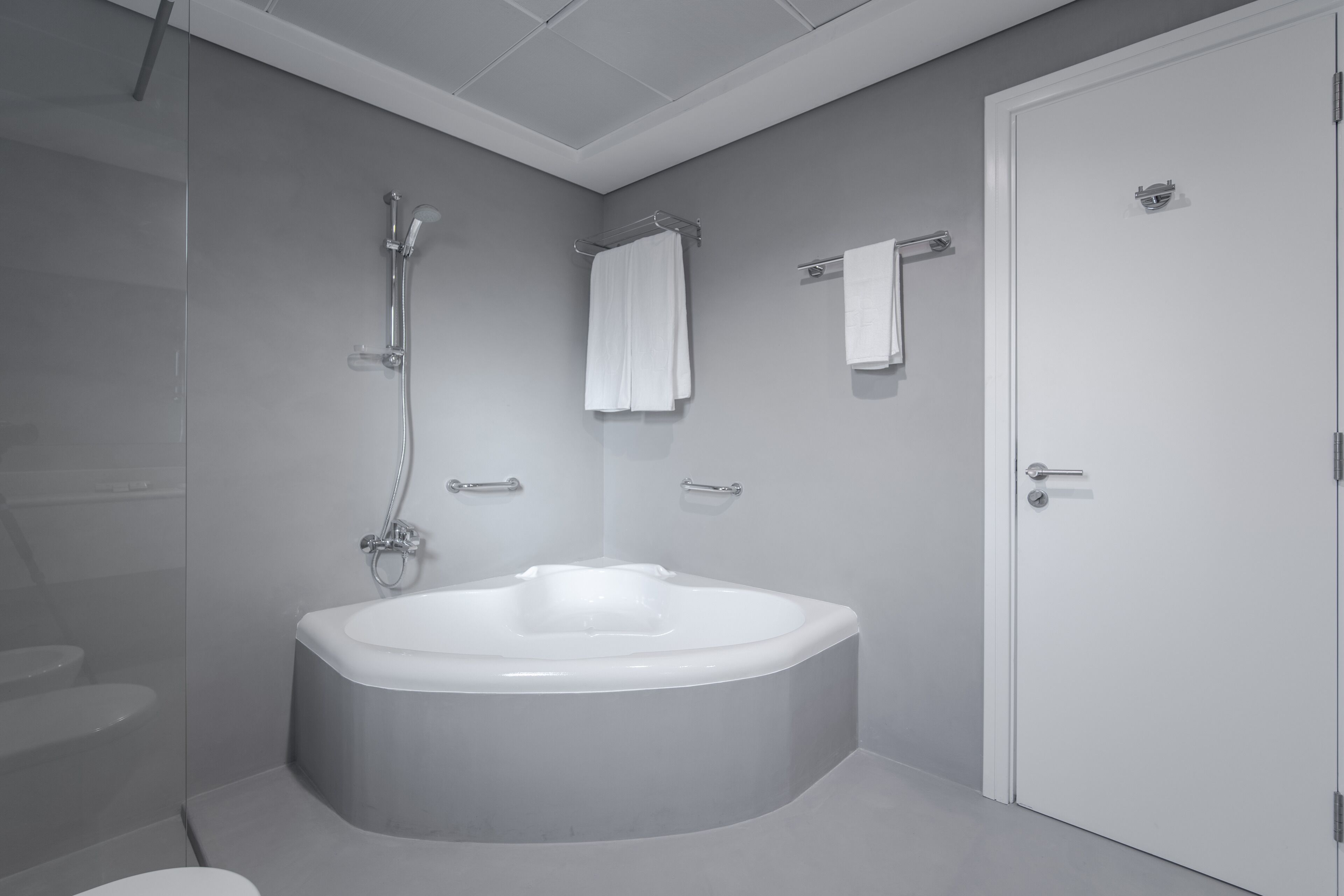 Une salle de bain moderne avec une baignoire sur pieds, une douche et des toilettes.