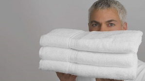 A person holding a stack of white towels. - Radegast CBD Beijing (Beijing)