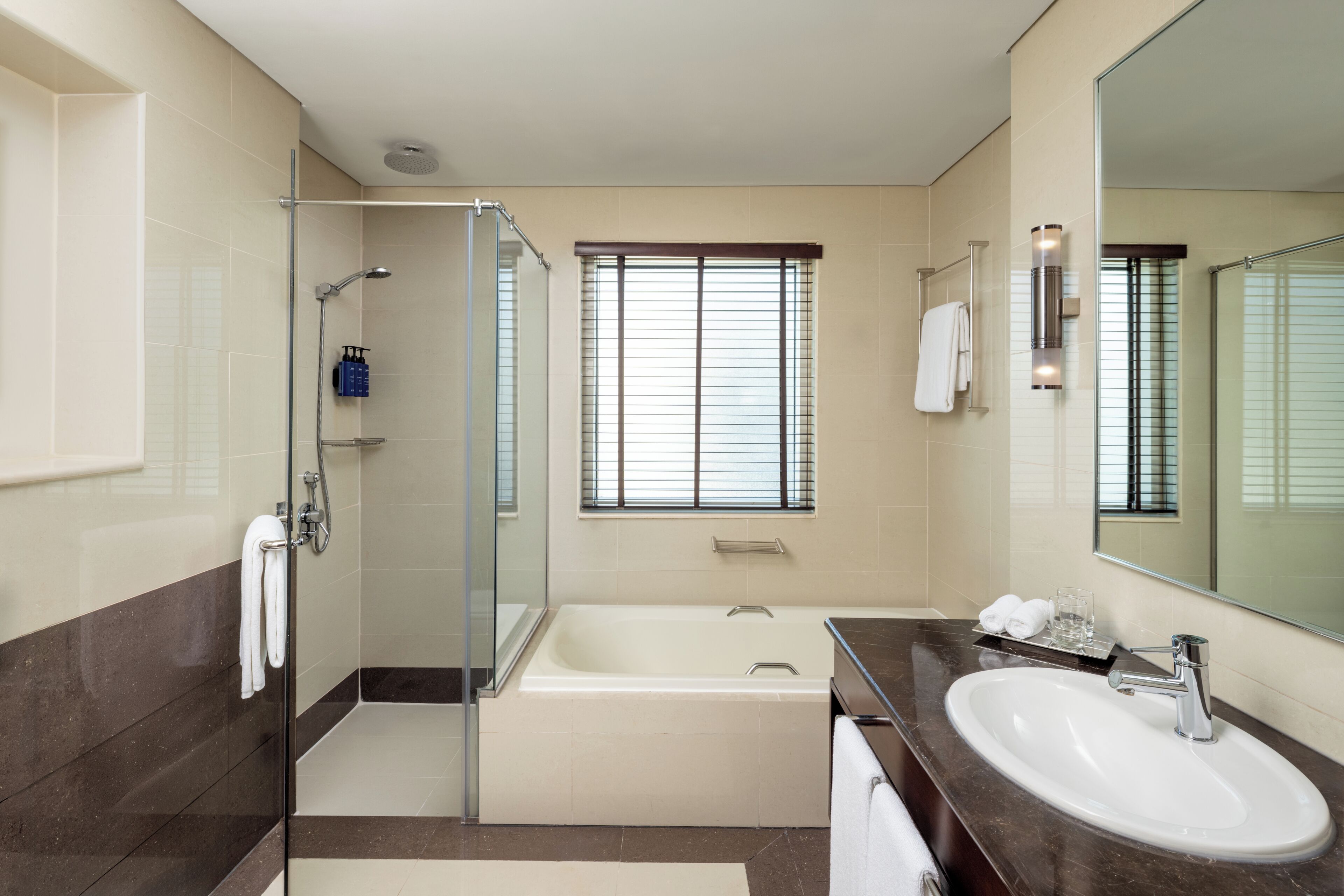 Un baño moderno con ducha de vidrio, bañera y lavamanos.