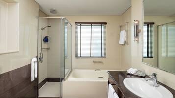 Un baño moderno con ducha de vidrio, bañera y lavamanos.