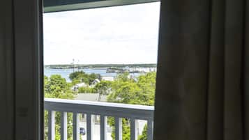 A view from a balcony overlooking a marina with boats, trees, and buildings.