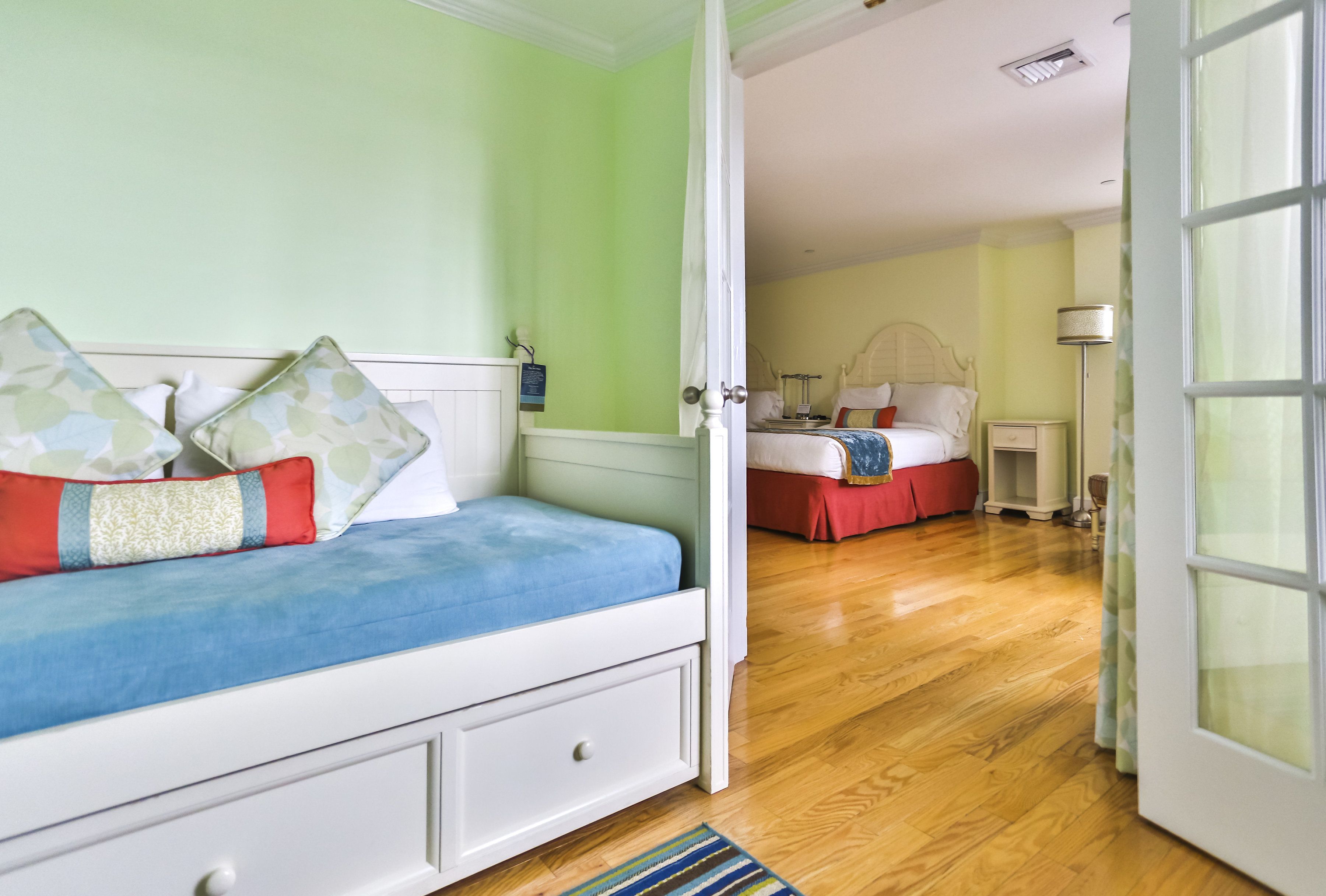 A bedroom with a bed, a nightstand, a lamp, and a window.