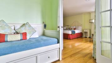 A bedroom with a bed, a nightstand, a lamp, and a window.