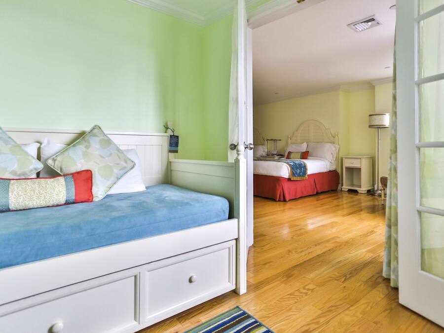 A bedroom with a bed, a nightstand, a lamp, and a window.