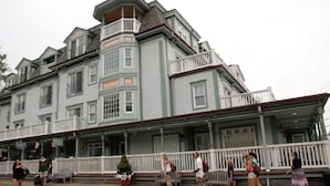 A multi-story building with a prominent bay window and a balcony. - Mansion House Inn And Spa (Vineyard Haven)