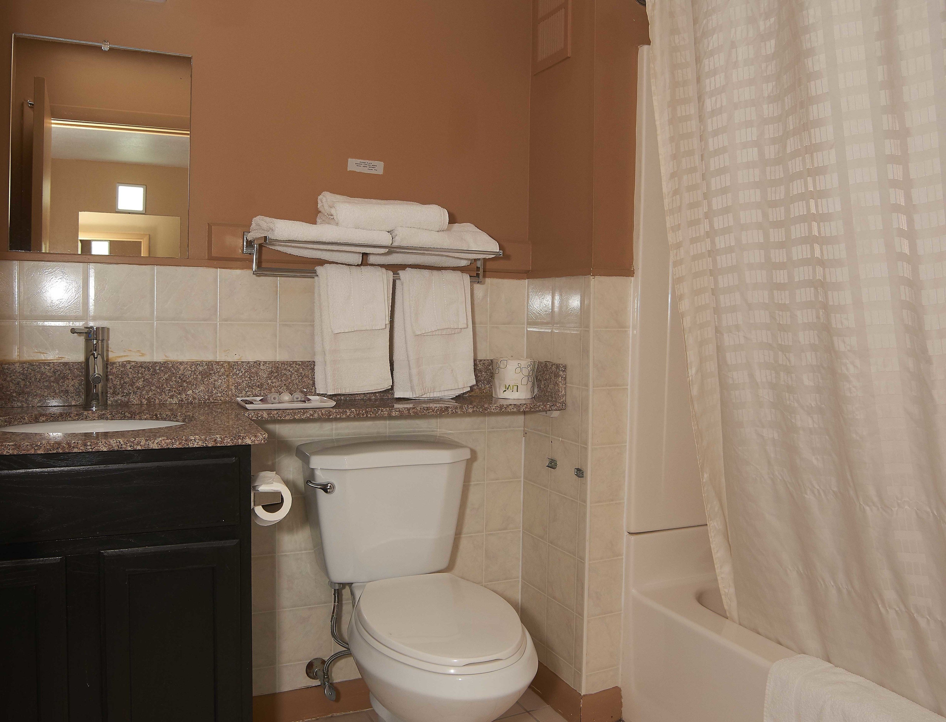 A bathroom with a toilet, sink, and a towel rack.