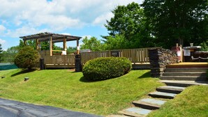 A wooden gazebo, stone steps, and a sign indicating a pool area. - New World Inn (Barre)