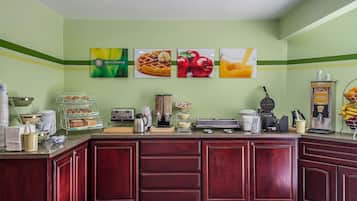 Un espace cuisine bien équipé, doté d’un comptoir où sont exposés divers produits alimentaires et appareils de cuisine.