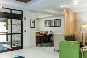 A hotel lobby with a reception desk, a fire alarm, a framed certificate, and a colorful striped artwork. - Holiday Inn Express Greenville by IHG (Greenville)