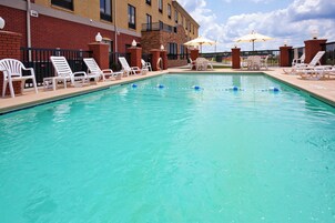 Una piscina al aire libre, sillones reclinables de piscina