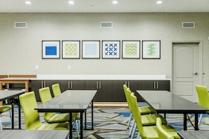 A conference room with a long table, green chairs, and framed wall art. - Holiday Inn Express Greenville by IHG (Greenville)