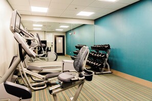 A gym with exercise equipment, a mirror, and a wall with a teal color. - Holiday Inn Express Greenville by IHG (Greenville)