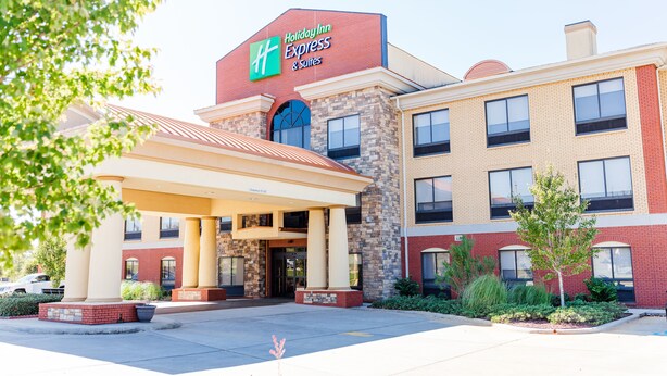 A Holiday Inn Express & Suites building with a brick facade, large windows, and a covered entrance area. - Holiday Inn Express Greenville by IHG (Greenville)