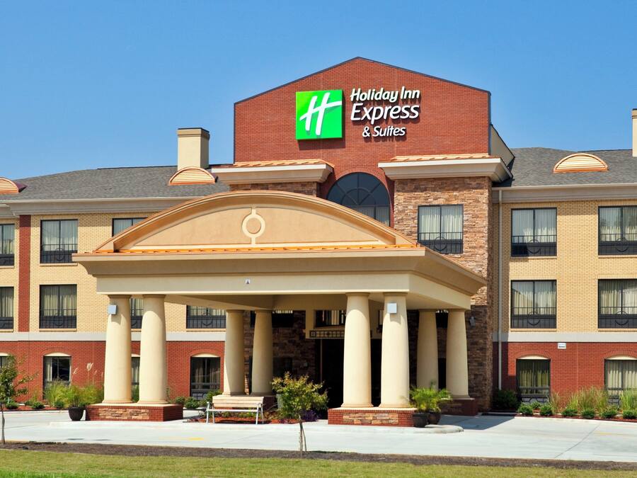 A Holiday Inn Express & Suites hotel with a prominent entrance, multiple windows, and a brick facade.