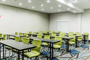 Un salón de conferencias con mesas y sillas dispuestas para reuniones.