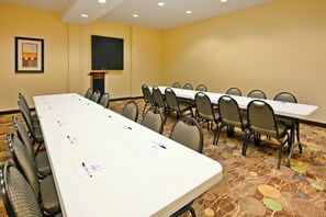 A conference room with a long table, chairs, a projector screen, and a framed picture on the wall. - Holiday Inn Express Greenville by IHG (Greenville)