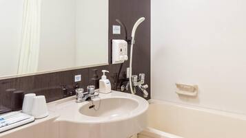 A bathroom with a sink, mirror, and shower.