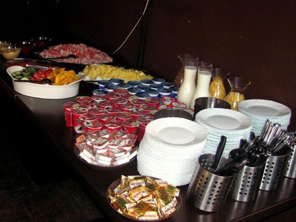 A buffet table with various food items, including fruits, meats, and condiments. - Pension Prague City (Prague)