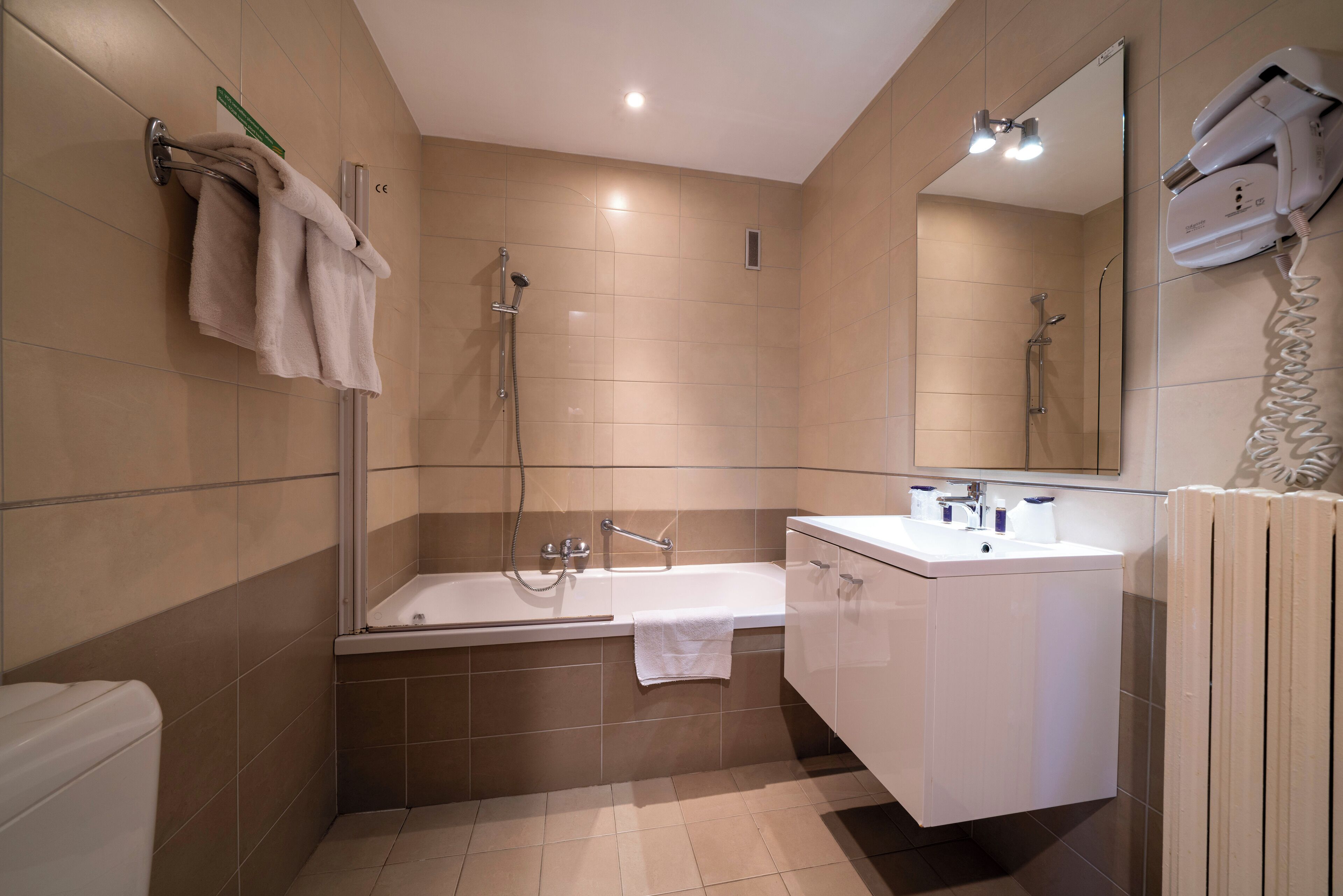 A modern bathroom with a bathtub, a sink, and a mirror.
