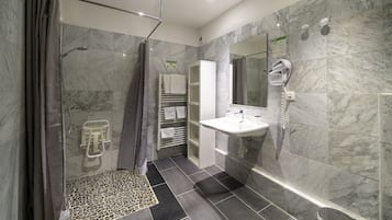Een moderne badkamer met een douche, een wastafel en een spiegel.