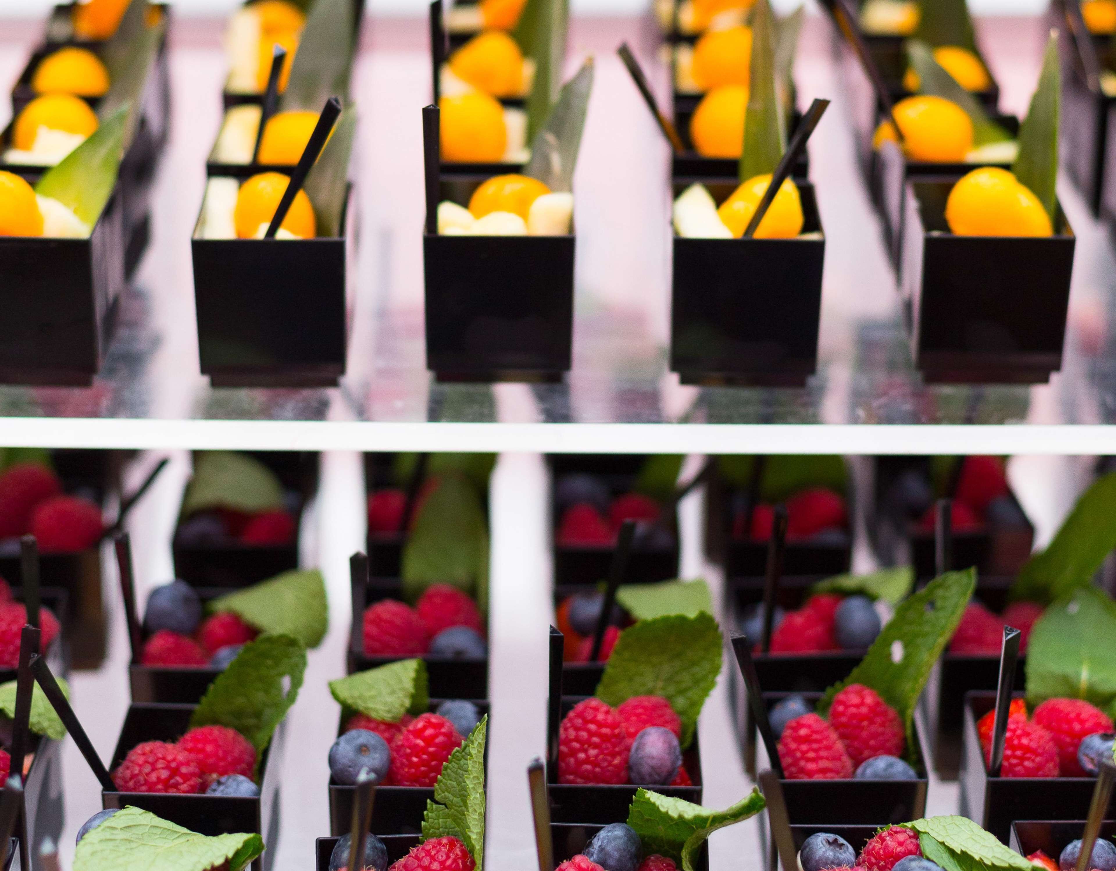 A series of black rectangular containers with fruits and leaves.