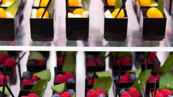 A series of black rectangular containers with fruits and leaves.