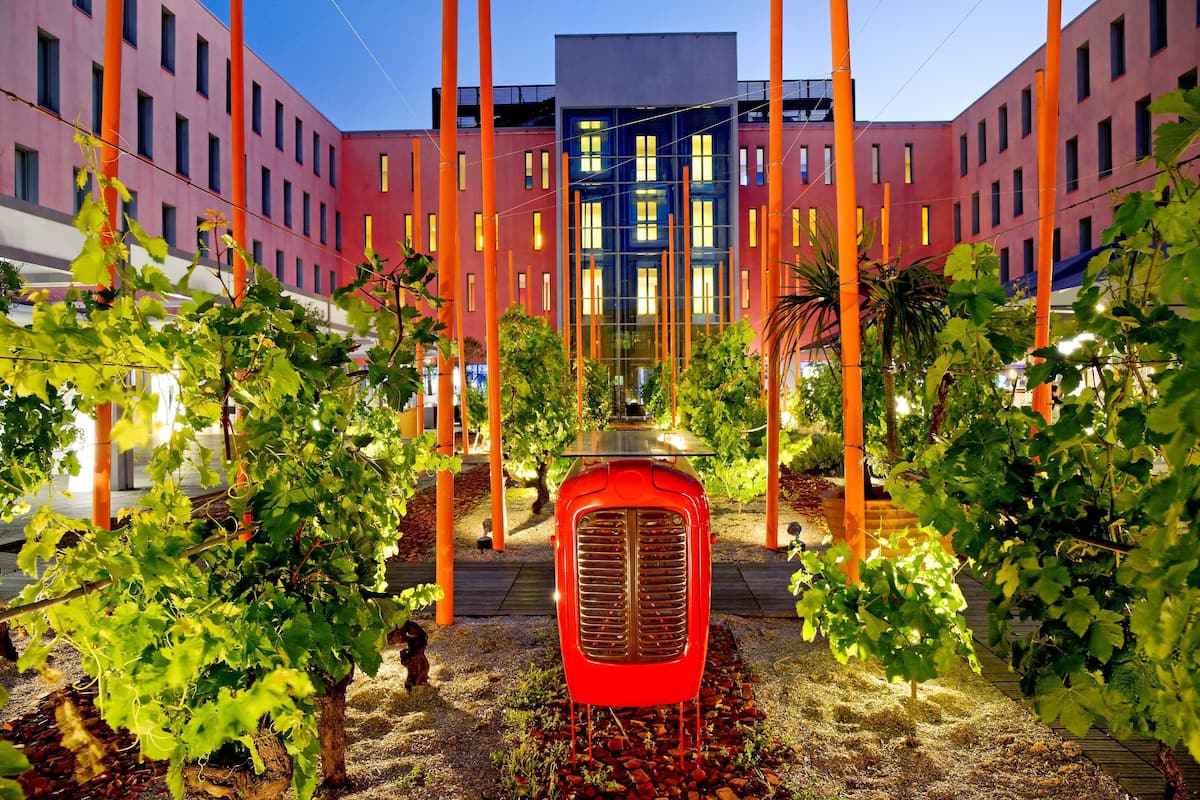 A modern building with a central glass facade and surrounding red brick walls.