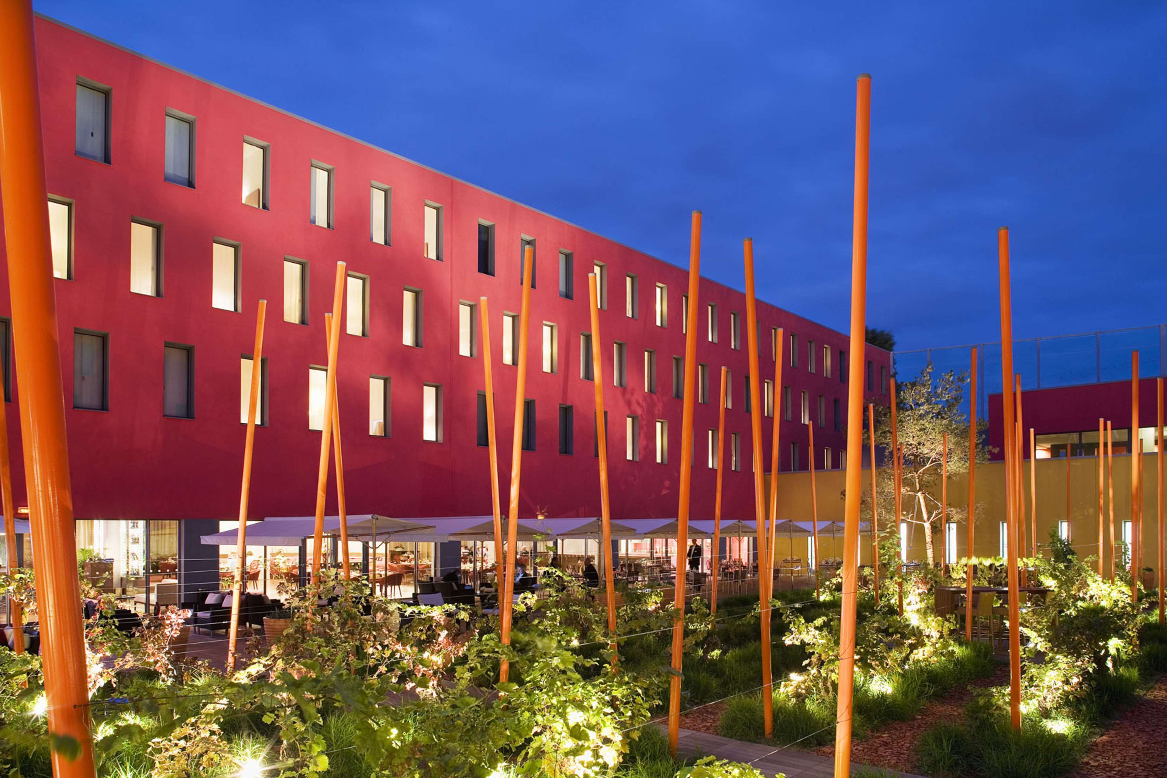 A modern building with multiple windows and a red facade.