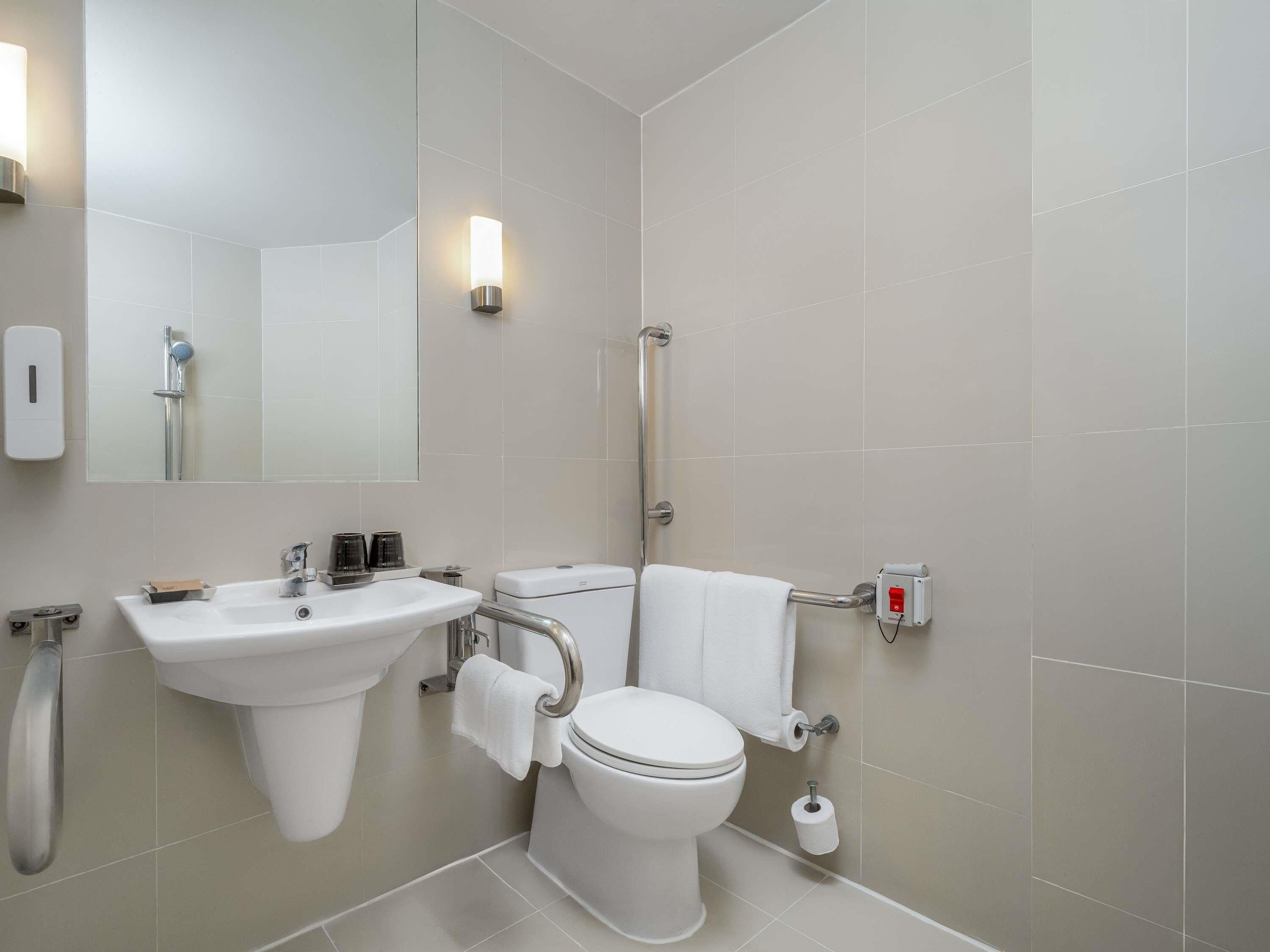 A modern bathroom with a sink, toilet, and shower.