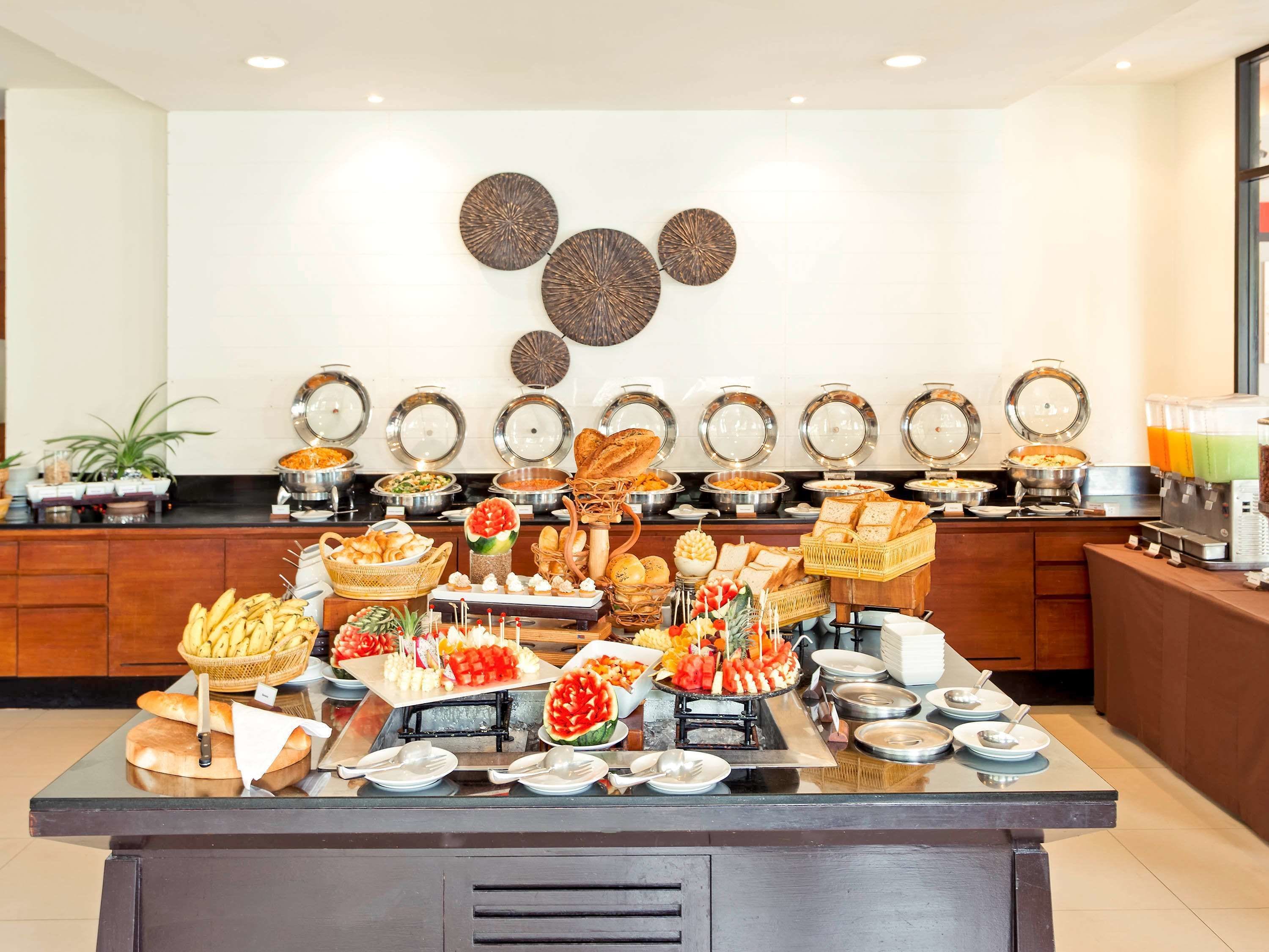 A buffet with various food items and a wall with decorative plates.