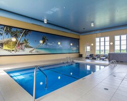 Una piscina techada, sillones reclinables de piscina