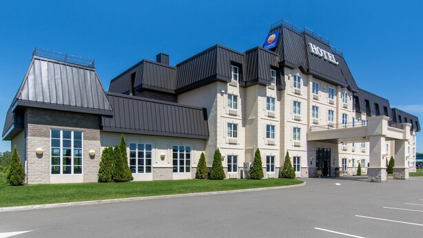 Un hôtel moderne, reconnaissable à son enseigne bien visible, doté de plusieurs étages et d’un parking.