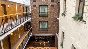 A multi-level atrium with a checkered floor, outdoor seating area, and a staircase. - Daugirdas Hotel (Kaunas)