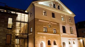 A multi-story building with a classical architectural style, featuring a prominent central entrance and multiple windows. - Daugirdas Hotel (Kaunas)