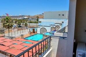 A rooftop pool with a view of a cruise ship and a mountainous landscape. - Costa Ensenada (Ensenada)