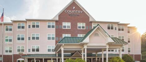 Un hôtel à plusieurs étages, reconnaissable à son enseigne bien visible indiquant « Country Inn & Suites by Radisson ».