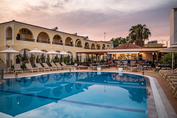 Alberca al aire libre por temporada y sombrillas en la alberca