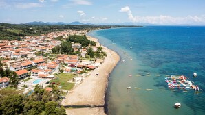 A coastal town with a beach, boats, and a clear sky. - Konstantina Apartments (Corfu)